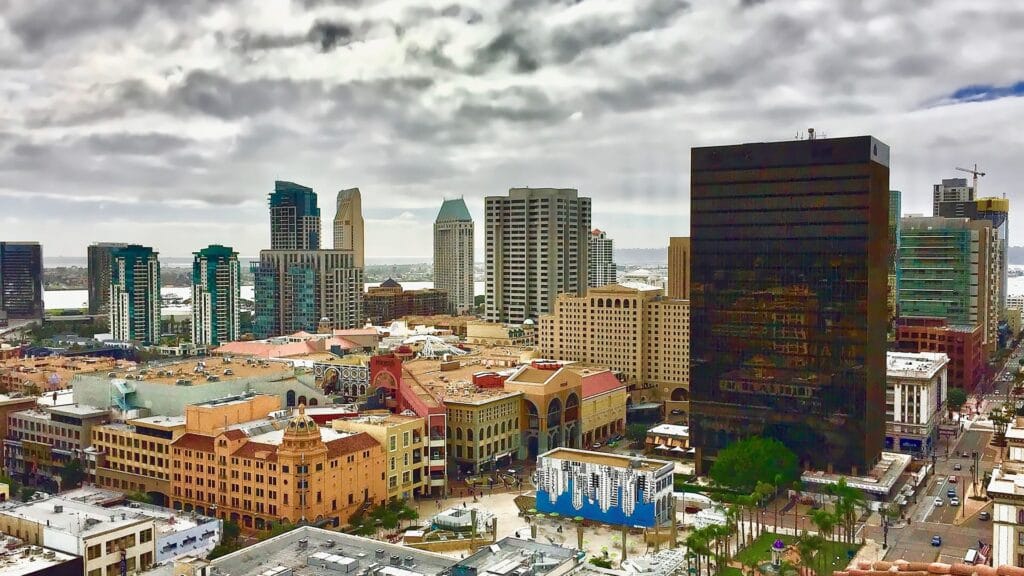 The skyline of San Diego is seen from the top of a building, overshadowed by the plight of homeless veterans dying in the streets.